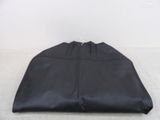 the large black bag is sitting on the floor next to a white wall