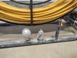 a yellow hose on the ground next to a yellow hose