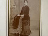 an old photo of a woman sitting on a chair