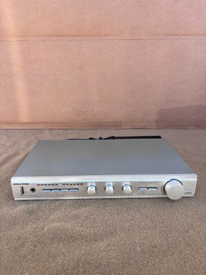 une image représentant un appareil électronique argenté posé sur un tapis marron