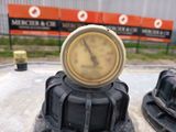 a clock on the top of a fire hydrant in the middle of a parking lot