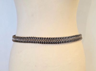 un gros plan sur le torse d'un mannequin portant une ceinture à maillons