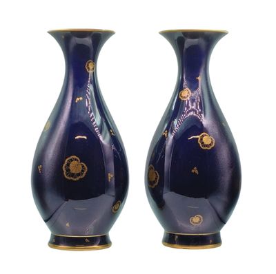une paire de vases bleus ornés de motifs dorés sur fond blanc