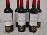 four bottles of wine are lined up on a table