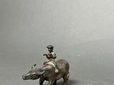 figurine of a man riding a boar with a bird on its back