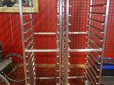 a picture of a metal rack with wheels and a bicycle in the background
