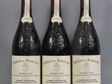 three bottles of wine are lined up on a table