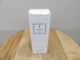 the box of the perfume is sitting on a wooden table