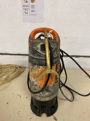 a gas can with a hose attached to it on the floor