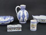 several pieces of blue and white pottery on a black background
