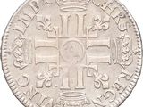 a close up of a silver coin with a cross on it