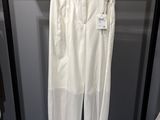 a white pants hanging on a rack in a clothing store