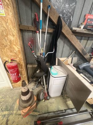 une photo d'un garage avec beaucoup d'outils sur le sol
