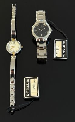 Trois montres sont posées sur une table, avec leurs étiquettes encore attachées.