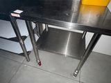 une table en acier inoxydable sur laquelle se trouve une tasse jaune