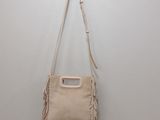 beige sued fringe bag hanging on a hook on a wall