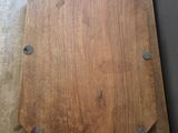 a wooden board with metal rivets sitting on a table