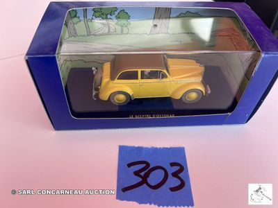 une petite voiture jaune dans une boîte bleue posée sur une table