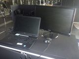 deux ordinateurs portables posés sur une table devant un écran d'ordinateur