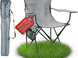 une chaise de jardin avec un parasol et un sac posés sur l'herbe