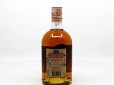 a close up of a bottle of liquor on a white surface