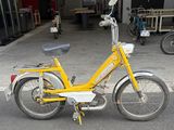 a small yellow bike parked in a parking lot