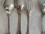 cinq cuillères et une fourchette sur une table