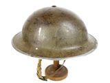 a metal helmet on a wooden stand on a white background