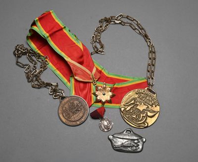 a red ribbon with a gold medal and a red ribbon with a silver medal and a red ribbon with a gold medal and a red ribbon with a crown