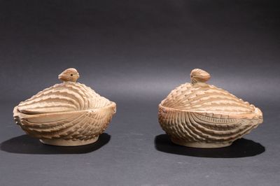une paire de coquillages sculptés posés l'un sur l'autre sur une surface noire