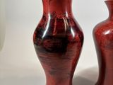two red vases sitting next to each other on a table