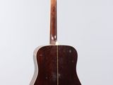 an acoustic guitar hanging from a wall with a white background