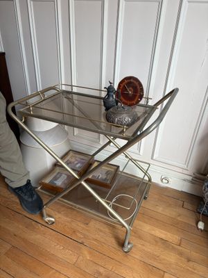un chariot de bar en verre et en métal posé sur un parquet