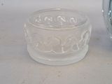 a clear glass cup sitting on a table next to a clock