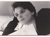 une photo en noir et blanc d'une femme tenant une feuille de papier