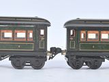 two toy trains sitting side by side on a white surface