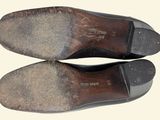 pair of brown leather shoes with black soles on a white surface