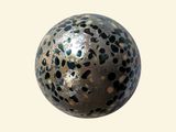 a silver ball with black spots on it