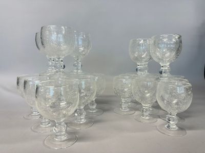 six clear glass goblets are lined up on a table