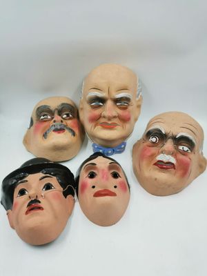 six masques représentant des hommes aux expressions faciales différentes, sur un fond blanc