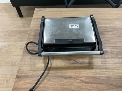 a toaster sitting on a table next to a chair