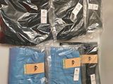 four pairs of men ' s blue and black pants are wrapped in plastic