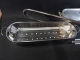a metal pan with a handle and a lid on a table