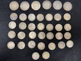 une image représentant un tas de vieilles pièces d'argent posées sur une surface noire