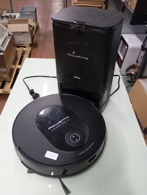 a black robot sitting on top of a table next to a black box