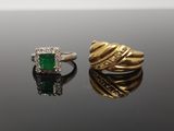 two gold rings with emerald stones and diamonds