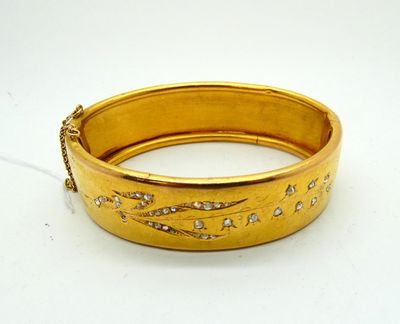 an image of a close up of a gold bracelet on a white surface