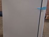 a white refrigerator sitting on the floor in a room