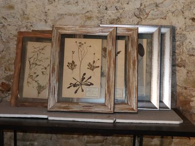 three framed pictures on a table in front of a brick wall