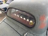 an old car that has been rusted and is parked in a parking lot